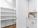 Walk-in pantry featuring white shelving, ample storage, and easy kitchen access at 410 S Church Ave, Tampa, FL 33609