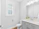 Well-lit half-bath with gray vanity, white countertop, and modern fixtures at 410 S Church Ave, Tampa, FL 33609