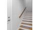 A modern staircase design with wooden treads, white risers, and a matching handrail against a clean white wall at 410 S Church Ave, Tampa, FL 33609