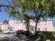 Exterior view of a two-story condo building with white trim, cars in parking lot, and mature trees at 4794 Cobia Se Dr # D, St Petersburg, FL 33705