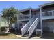 Exterior of condominium building with staircase to the second level, white railings and a lawn area at 4794 Cobia Se Dr # D, St Petersburg, FL 33705