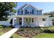 Charming two-story home with a blue exterior and a beautifully landscaped front yard at 5235 9Th N Ave, St Petersburg, FL 33710