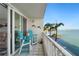 Relaxing balcony featuring blue chairs, palm trees, and a beautiful waterfront view at 5279 Isla Key S Blvd # 212, St Petersburg, FL 33715