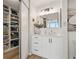 Bathroom with a white vanity, a large mirror, and an organized closet at 5279 Isla Key S Blvd # 212, St Petersburg, FL 33715