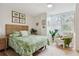 Bright bedroom featuring a wicker bed frame, tropical bedding, and a cozy armchair by the window at 5279 Isla Key S Blvd # 212, St Petersburg, FL 33715
