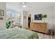 Bedroom with a tropical theme, featuring a large window, wooden dresser, and view of a walk-in closet at 5279 Isla Key S Blvd # 212, St Petersburg, FL 33715