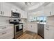 Modern kitchen with stainless steel appliances, granite countertops, and views to the water at 5279 Isla Key S Blvd # 212, St Petersburg, FL 33715