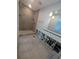Bathroom featuring a tiled shower with pebble accents, a light-up mirror, and new light colored floors being remodeled at 5434 Oakhurst Dr, Seminole, FL 33772