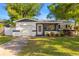 Charming single-story home with a well-maintained lawn, a screened porch and a white garage at 5809 Dartmouth N Ave, St Petersburg, FL 33710
