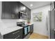 Modern kitchen features stainless steel appliances, black cabinets with gold hardware, and white countertops at 5809 Dartmouth N Ave, St Petersburg, FL 33710