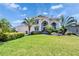 Beautiful home with lush green lawn, manicured landscaping, and tropical palm trees, creating a welcoming exterior at 706 Bunker View Dr, Apollo Beach, FL 33572