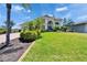 Beautiful home with lush green lawn and mature tropical landscaping adding to the curb appeal at 706 Bunker View Dr, Apollo Beach, FL 33572