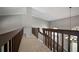 Second floor hallway with wooden railing and a view of the entryway at 706 Bunker View Dr, Apollo Beach, FL 33572