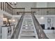 Carpeted staircase view with wood railings and a view of the living room fireplace at 706 Bunker View Dr, Apollo Beach, FL 33572