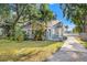 Charming historic home with manicured lawn, tropical landscaping, and inviting front porch at 103 S Habana Ave, Tampa, FL 33609