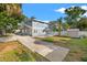 Two-story home with a concrete driveway, fenced yard and lush trees on a sunny day at 103 S Habana Ave, Tampa, FL 33609