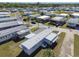 A mobile home community boasts well-maintained homes with metal roofs and tree-lined streets from an aerial view at 13225 101St St # 107, Largo, FL 33773
