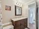 Bathroom features a wood vanity with white counters and access to a hallway at 13225 101St St # 107, Largo, FL 33773