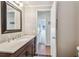Bathroom with a wood vanity, a large mirror, and a view to a hallway at 13225 101St St # 107, Largo, FL 33773