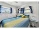 Bright bedroom features a colorful quilt, white walls and two windows providing natural light at 13225 101St St # 107, Largo, FL 33773