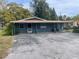 Charming single-story home with a covered parking area and mature trees surrounding the property at 14612 Coral Dr, Hudson, FL 34667