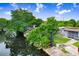 Picturesque view of a lush backyard extending to a tranquil canal with waterfront properties under a partly cloudy sky at 14612 Coral Dr, Hudson, FL 34667