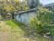 Side yard of a charming home featuring lush greenery and plenty of space for outdoor activities at 14612 Coral Dr, Hudson, FL 34667