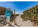 Beach access pathway lined with lush greenery and a warning sign about swimming at your own risk at 15 Glendale St # B6, Clearwater Beach, FL 33767