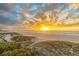 Beautiful sunset over a sandy beach with dunes and the ocean, creating a serene and picturesque scene at 15 Glendale St # B6, Clearwater Beach, FL 33767