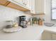 Kitchen countertop detail featuring a coffee maker, dishes, and decorative backsplash at 15 Glendale St # B6, Clearwater Beach, FL 33767