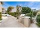 Outdoor grill with stainless steel doors and stone countertop surrounded by greenery and a pathway at 15 Glendale St # B6, Clearwater Beach, FL 33767