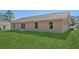 Well-maintained backyard with a green lawn, sliding glass door, and neutral stucco exterior at 15409 Coot Rd, Weeki Wachee, FL 34614