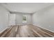 A bright bedroom with wood-look flooring, neutral walls, a window and white trim at 15409 Coot Rd, Weeki Wachee, FL 34614