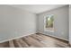 Bedroom with a window overlooking an outside view, neutral paint, and wood-look flooring at 15409 Coot Rd, Weeki Wachee, FL 34614