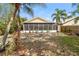 Backyard featuring mature landscaping, partial fence, firepit, and screened porch at 15838 49Th N St, Clearwater, FL 33762