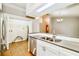 Modern kitchen with stainless steel appliances and tile flooring adjacent to laundry area at 15838 49Th N St, Clearwater, FL 33762