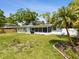 Large, grassy backyard with mature trees, a screened patio, and outdoor seating, ideal for relaxation and entertaining at 1666 N Dakota Ne Ave, St Petersburg, FL 33703