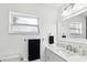 Bathroom with white vanity, marble countertops, black hand towel, and a window at 1666 N Dakota Ne Ave, St Petersburg, FL 33703