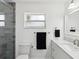 Bathroom with white vanity, marble countertops, black hand towel, and walk-in shower at 1666 N Dakota Ne Ave, St Petersburg, FL 33703