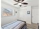 This is a cozy bedroom featuring wood laminate flooring, a ceiling fan, and built-in closets at 1666 N Dakota Ne Ave, St Petersburg, FL 33703