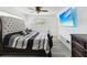 This is a stylish bedroom featuring a tufted headboard, modern ceiling fan, and large flat-screen television at 1666 N Dakota Ne Ave, St Petersburg, FL 33703