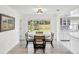 Cozy dining area adjacent to a kitchen, featuring a round table, stylish chairs, and natural light from the window at 1666 N Dakota Ne Ave, St Petersburg, FL 33703
