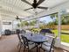 This screened-in patio features an outdoor dining table, ceiling fans, and views of the backyard at 1666 N Dakota Ne Ave, St Petersburg, FL 33703