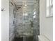 Beautifully tiled walk-in shower featuring upgraded shower head, glass door, and pebble floor at 1666 N Dakota Ne Ave, St Petersburg, FL 33703