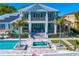 A two-story waterfront home featuring balconies, a pool, and a patio with colorful lounge chairs at 1695 Brightwaters Ne Blvd, St Petersburg, FL 33704