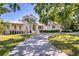 Beautiful home with lush landscaping, brick driveway, and unique pineapple sculpture at 1695 Brightwaters Ne Blvd, St Petersburg, FL 33704