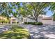 Stunning home featuring mature trees, brick driveway, and meticulous landscaping at 1695 Brightwaters Ne Blvd, St Petersburg, FL 33704