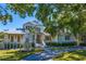 Stately home with a lush front lawn, a circular driveway, and a decorative pineapple sculpture at 1695 Brightwaters Ne Blvd, St Petersburg, FL 33704