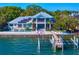Waterfront home with private dock and boat lift, pool, two-story balconies and a light blue exterior at 1695 Brightwaters Ne Blvd, St Petersburg, FL 33704