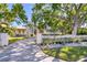 Charming two-story home with lush landscaping, a circular driveway and white picket fence at 1695 Brightwaters Ne Blvd, St Petersburg, FL 33704